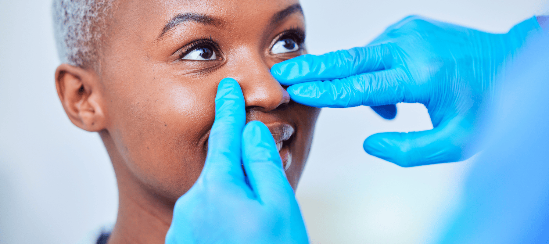 woman getting nose examined by doctor